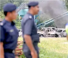  ?? — Bernama photo ?? The burnt cars can be seen outside the Hindu temple.