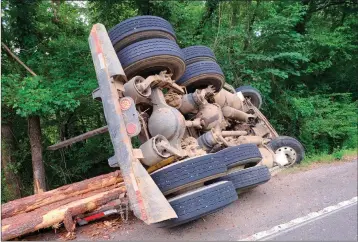  ?? Special to The Saline Courier ?? A severely damaged logging truck sits on its side in Benton Wednesday after being involved in a two-vehicle accident that led to the death of one individual.