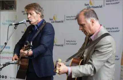  ?? VANESSA TIGNANELLI, RECORD STAFF ?? Blue Rodeo’s Jim Cuddy, left, and Kitchener Public Library’s Bob Egan put on a performanc­e Monday during an event to announce the Sun Life Financial musical instrument lending program.