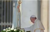  ?? — AFP ?? Pope Francis touches a statue of Our Lady of Fatima at St Peter’s square at the Vatican. Pope will go to Fatima on Friday on a pilgrimage to canonise two child shepherds who reported apparition­s of the Virgin Mary 100 years ago.