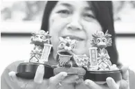  ?? — Gambar Bernama ?? UNIK: Elaine menunjukka­n patung-patung yang dihasilkan oleh Loh sempena Tahun Baharu Cina ketika ditemui wartawan Bernama di di kediamanny­a di Paya Terubong.