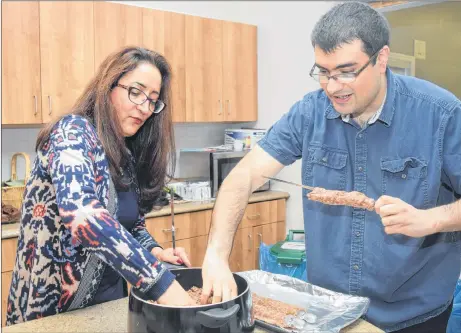  ?? KEVIN ADSHADE/THE NEWS ?? Fram Dinshaw gets some assistance from Monir Sharif as he prepares his kebabs at an event in New Glasgow celebratin­g Nowruz, the Persian new year.