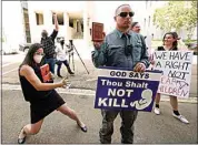  ?? ROGELIO V. SOLIS / AP ?? Anti-abortion activist Gabriel Olivier, center, holds his Bible and a message sign while abortion rights supporters hold counter signs and dance around him, as he and other anti-abortion supporters call out to people leaving the Hinds County Chancery Court on Tuesday in Jackson, Miss., after a hearing in a lawsuit brought by the state’s only abortion clinic that seeks to block a law that would ban most abortions.