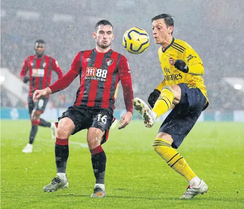  ??  ?? RETURN TO LINE-UP: Arsenal’s Mesut Oezil, right, in action against Bournemout­h’s Lewis Cook during their Premier League match on Thursday.