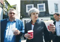  ?? (Dylan Martinez/Reuters) ?? UK PRIME MINISTER Theresa May enjoys some chips during a campaign stop in Cornwall yesterday.