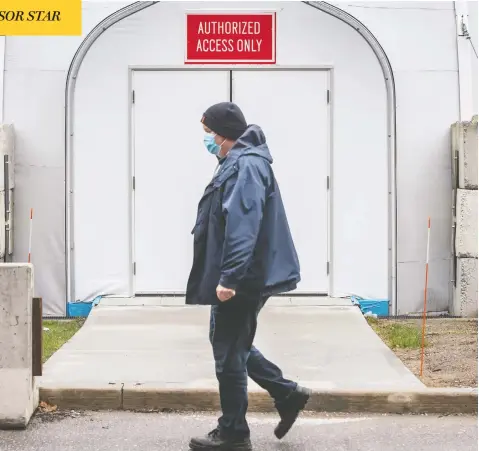  ?? PETER J THOMPSON / NATIONAL POST ?? A man passes a COVID field unit — Ontario's first — which began taking patients this week at Burlington's Joseph Brant Hospital.