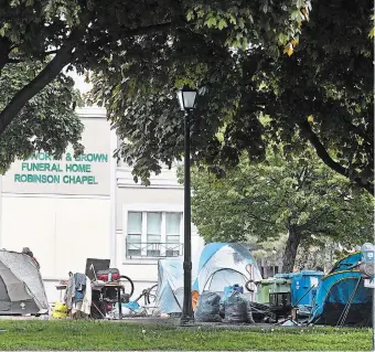  ?? CATHIE COWARD THE HAMILTON SPECTATOR ?? A growing homeless encampment in a park in front of Dodsworth and Brown Funeral Home on Wellington Street at King Street East is spurring complaints.
