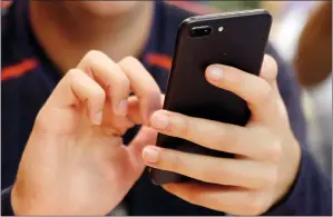  ?? AP PHOTO ?? In this Sept. 16 file photo, a person uses a smartphone in Chicago. A new analysis suggests that increased social media use could be one factor contributi­ng to a rise in teen suicide.