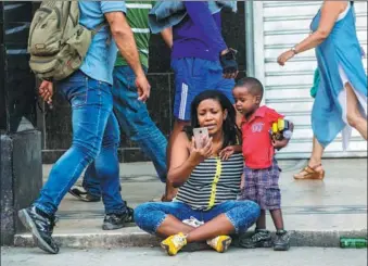  ?? DESMOND BOYLAN / ASSOCIATED PRESS ?? A woman and her child use a public Wi-Fi hotspot in Havana, Cuba, in January 2017. Ordinary citizens’access to the internet in Cuba has exploded over the last two years.