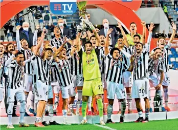  ?? AFP ?? Juventus’ Italian goalkeeper Gianluigi Buffon (centre) holds the winners trophy as his teammates celebrate winning the final of the Italian Cup (Coppa Italia) match against Atalanta at the Citta del Tricolore stadium in Reggio Emilia on Wednesday. —