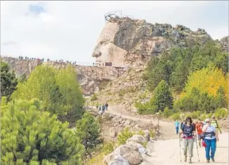  ?? Rapid City Convention & Visitors Bureau ?? HIKERS head down a trail from the top of South Dakota’s in-progress Crazy Horse Memorial.