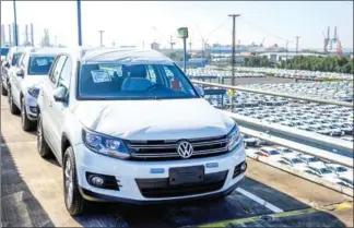  ?? INGO WAGNER/DPA/AFP ?? A new Volkswagen car is seen in the foreground as parked cars are ready for shipping at the car terminal of the port of Bremerhave­n, northweste­rn Germany.