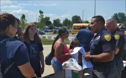  ?? KEITH REYNOLDS — THE MORNING JOURNAL ?? Lorain police officers ran out of free school supplies within the first hour of Lorain City Schools’ back-to-school extravagan­za Aug. 11 at Lorain High School, 2600 Ashland Ave. in Lorain.