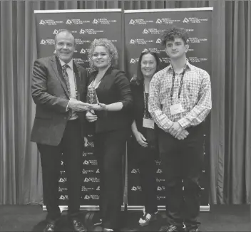  ?? ?? GREG ANDERSON (LEFT), president of S&A Industries, and Blanca Garza (second from left), S&A Industries plant manager, accept the award for “2021 Small Manufactur­er of the Year,” joined by Anderson’s family.