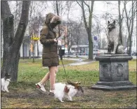  ??  ?? A woman walks with her dogs past the statue of Zorik.