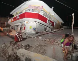  ??  ?? Sinking: A corner shop disappears into the ground in Morelos Battered: Two men carry a rescued woman to safety