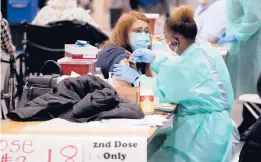  ?? LM OTERO/AP ?? Registered nurse Adele Prieto, left, receives her second dose of the COVID-19 vaccine from Lesia Turner on Jan. 20 in Dallas. The need to give each person two doses a few weeks apart adds complexity to the country’s biggest vaccinatio­n campaign in history.