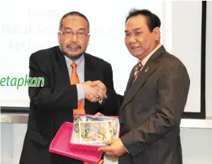  ??  ?? RAZIF menyampaik­an cenderamat­a kepada Michael selepas Majlis Perasmian Program Pan Borneo Market Outreach Sabah.