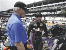  ?? DARRON CUMMINGS/AP ?? NASCAR TEAM OWNER JOE GIBBS (left) talks with Denny Hamlin before the Brickyard 400 auto race at Indianapol­is Motor Speedway in Indianapol­is, July 27, 2014.