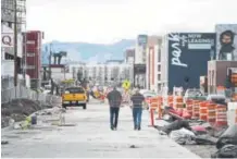  ?? AAron Ontiveroz, The Denver Post ?? Neil Watson, left, and Dallin Jones walk through constructi­on in the RiNo neighborho­od because of a lack of sidewalks.