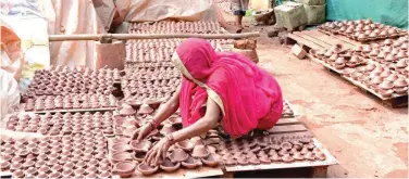  ?? Agencefran­ce-presse ?? A potter arranges earthen oil lamps kept for drying at a workshop ahead of the Navratri festival on the outskirts of Ahmedabad on Monday.