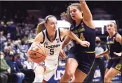  ?? Jessica Hill / Associated Press ?? Paige Bueckers dribbles around Notre Dame’s Madelyn Westbeld in the first half their game on Sunday in Storrs.