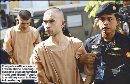  ?? AP ?? Thai police officers escort Erawan shrine bombing suspects Bilal Mohammad (front) and Mieraili Yusufu to a military court in Bangkok yesterday.