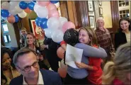  ?? CORY MORSE — THE GRAND RAPIDS PRESS VIA AP ?? Hillary Scholten, right, the Democratic candidate in Michigan’s 3rd Congressio­nal District, hugs supporters during an election watch party at Paddock Place in Grand Rapids on Tuesday.