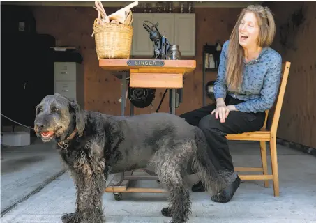  ?? Jessica Christian / The Chronicle ?? Lori Stone, shown at home in Redwood City with her dog, Reese, had already done genetic testing before hearing of her siblings.