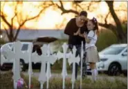  ?? JAY JANNER/AUSTIN AMERICAN-STATESMAN VIA AP ?? Meredith Cooper, of San Antonio, Texas, and her 8-year-old daughter, Heather, visit a memorial of 26 metal crosses near First Baptist Church in Sutherland Springs, Texas, Monday. The gunman of a deadly shooting at the smalltown Texas church had a...