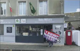  ?? COURTESY OF PHILIPPE TANNE VIA AP ?? Philippe Tanne, of France, holds a “Trump 2020” flag outside the military memorabili­a store he runs in the Normandy town of Sainte-Marie-du-Mont on Tuesday.