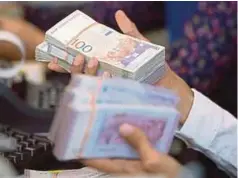  ?? BLOOMBERG PIC ?? Maybank Kim Eng is looking at ringgit’s fair value of RM3.65 to the dollar.