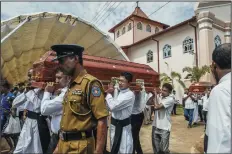  ?? ATUL LOKE/GETTY IMAGES ?? Priests from a local church carry the coffins for the religious Mass at St. Sebastian Church on Tuesday in Negambo, Sri Lanka.