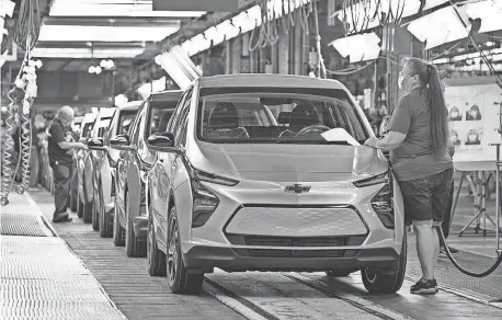  ?? PROVIDED BY STEVE FECHT FOR CHEVROLET ?? Kimberly Fuhr inspects a Chevrolet Bolt EV on May 6, 2021, at the General Motors Orion Assembly plant in Orion Township. GM said earlier this year it will stop production of the Bolts there this year to focus on the 2024 Silverado EV pickup.