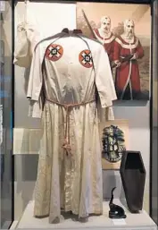  ??  ?? A KU KLUX KLAN outfit and memorabili­a are featured in the museum. There are also the names of those killed in more than 600 documented lynchings.