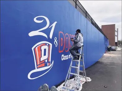  ?? Contribute­d photo ?? Joe Di Guiseppi, an art teacher at Westside Middle School, paints a mural honoring the Class of 2021 at Danbury High School on Saturday.