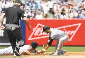  ?? Jim McIsaac / Associated Press ?? The Yankees’ Brett Gardner dives back safely avoiding the tag from Rays second baseman Brandon Lowe on a pick off attempt as umpire Ted Barrett watches the play during the third inning on Saturday.