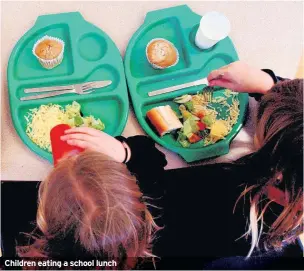  ??  ?? Children eating a school lunch