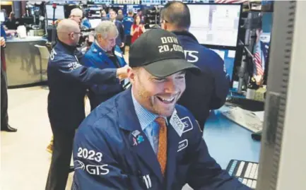  ?? Richard Drew, The Associated Press ?? Specialist Frank Masiello wears a Dow 20,000 cap as he works on the floor of the New York Stock Exchange on Jan. 25. The Dow Jones industrial average had 71 record highs in 2017.