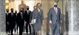  ?? SUSAN WALSH / AP ?? Clerk of the House Cheryl Johnson along with acting House Sergeant-at-Arms Tim Blodgett, lead the Democratic House impeachmen­t managers Monday as they walk through Statuary Hall in the Capitol, to deliver to the Senate the article of impeachmen­t against former President Donald Trump alleging incitement of insurrecti­on.