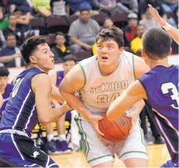  ?? JIM THOMPSON/JOURNAL ?? Texico’s Nathan Phipps looks to the hoop as two Santa Rosa defenders converge. Phipps, a 6-foot-5, 245-pounder, had 21 points and 12 rebounds in the Wolverines’ semifinal victory.