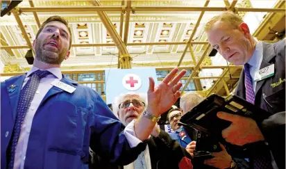  ?? (Brendan Mcdermid/Reuters) ?? TRADERS WORK on the floor of the New York Stock Exchange yesterday. The Cboe Volatility Index, known as the VIX, the most widely followed barometer of expected near-term volatility for the S&P 500 index, eased after rising sharply earlier in the week.