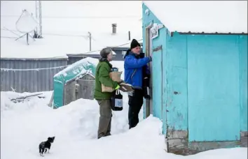  ?? Gregory Bull/Associated Press ?? Census Bureau director Steven Dillingham, right, knocks on the door alongside census worker Tim Metzger as they arrive to conduct the first enumeratio­n of the 2020 Census on Jan. 21 in Toksook Bay, Alaska.