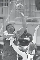  ?? DAVID RICHARD/ USA TODAY SPORTS ?? Pelicans forward Zion Williamson shoots over Cavaliers forward Dean Wade.