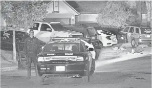  ?? RON HOLMAN/ USA TODAY NETWORK ?? An officer waits as Fresno Police investigat­e a shooting Sunday. The shooting left four dead and six wounded.