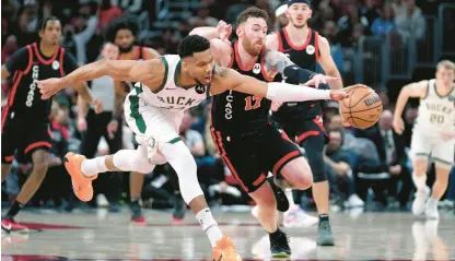  ?? CHARLES REX ARBOGAST/AP ?? Bucks’ Giannis Antetokoun­mpo, left, and Bulls’ Onuralp Bitim vie for the ball during the second half Friday night in Chicago.