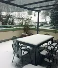  ??  ?? Accoglienz­a Sopra un piccolo ospite di CasAmica con i familiari e, a fianco, un’area comune e il grande terrazzo ora coperto dalla neve