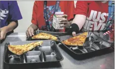  ?? ALBERTO MARIANI/AP ?? SECOND-GRADE STUDENTS SELECT THEIR MEALS during lunch break in the cafeteria at an elementary school in Scottsdale on Dec. 12, 2022.