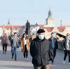  ?? PETR DAVID JOSEK/AP ?? The Czech Republic last week had a record 8,500 people hospitaliz­ed with COVID-19. Above, a man walks across the Charles Bridge on Feb. 25 in Prague.