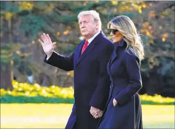  ?? Evan Vucci Associated Press ?? PRESIDENT TRUMP, with wife Melania, also opposes renaming bases named for Confederat­e generals.
